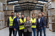 © Halfpoint - Full team of warehouse employees standing in warehouse. Team of workers, managers, female director in modern industrial factory, heavy industry, manufactrury.