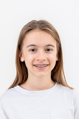 brunette girl smiling with braces on her teeth on a white background isolated.