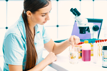 Wall Mural - young woman in the laboratory measures the acidity of drinking water using a rapid test