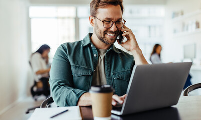 Poster - Male software designer speaking to a client on the phone in an office