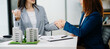 © Nuttapong punna - Real estate broker agent presenting and consult to customer to decision making sign insurance form agreement, home model, concerning mortgage loan offer.