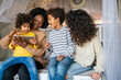 © NDABCREATIVITY - Family children gay parents concept. Happy multiethnic women couple having fun with kids at home