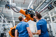 © Westend61 - Two technicians examining industrial robot in a factory
