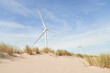 © Westend61 - Wind turbines on sand dune under cloudy sky