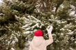 © Westend61 - Woman touching snow covered spruce tree in winter forest