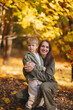 © Алеся Сутягина - Mom and children walk in the park and enjoy the beautiful autumn nature. Happy family on an autumn walk. Natural Park. Family active holiday concept.