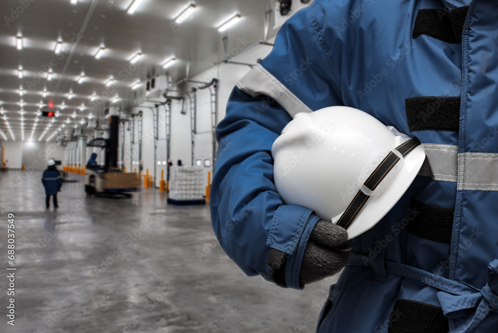 Officer holding hardhat for dangerous accident protection in warehouse ...