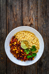 Wall Mural - Chili con carne with rice on wooden table