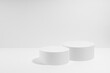 Abstract two white round podiums for cosmetic products in hard light, mockup on white background. Scene for presentation products, gifts, goods, advertising, design, sale, display in minimal style.
