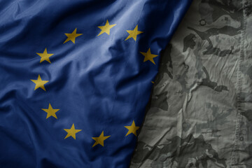 waving flag of european union on the old khaki texture background. military concept.