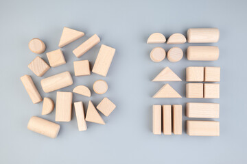 many different geometric wooden toys in confused positions on the left, rearranged into the same typ