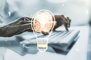 Poster - Creative light bulb with human brain hologram and with hands typing on computer keyboard on background, artificial Intelligence and neural networks concept. Multiexposure