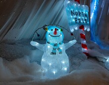 Transparent Snowman Ornament And A Beautifully Decorated Signpost Showing North Pole Are Made Of Glass And Plastic And Are Being Shown During A Christmas Show In A Shop