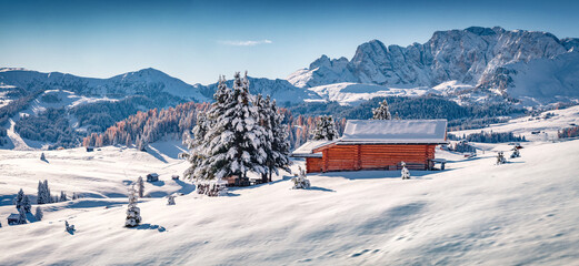 Poster - Panoramic morning view of Alpe di Siusi village with wooden chalet. Sunny winter landscape of Dolomite Alps. Snowy outdoor scene of ski resort, Ityaly, Europe. Vacation concept background.