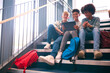 Three Male Secondary Or High School Pupils Inside School Building On Stairs With Digital Tablet
