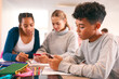 © Monkey Business - Secondary Or High School Students In Study Area Working Together Using Mobile Phones