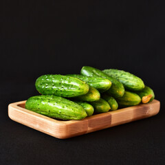 Wall Mural - cucumbers on a wooden board close-up, dark background, no people