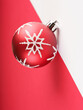 décoration de noël, boule rouge avec flocon de neige blanc, sur fond blanc et rouge