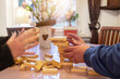 At Easter, the family plays board games together. Wife and husband build a wobbly tower out of wooden blocks. In the background is the Easter bouquet with Easter eggs. Motion blur.