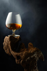 Wall Mural - Snifter of brandy on a old wooden snag.