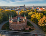 Fototapeta Desenie - Barbicane (Barbakan), part of medieval gothic city fortification in the sunny autumn morning, aerial view, Krakow, Poland