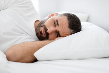 Wall Mural - Sleepy Bearded European Man Lying In Bed Awake At Home