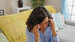 © Krakenimages.com - Middle age hispanic woman suffering for headache taking glasses off at home