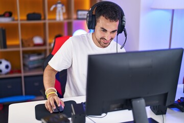 Poster - Young hispanic man streamer playing video game using computer at gaming room