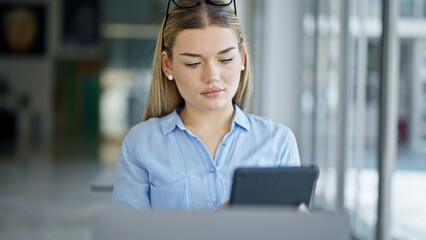 Wall Mural - Young blonde woman business worker using laptop and touchpad at office