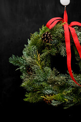 Wall Mural - Christmas wreath decorated with pine cones and red ribbon