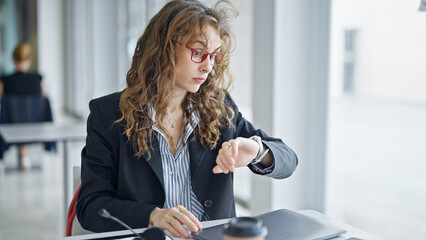 Poster - Young woman business worker looking watch at the office