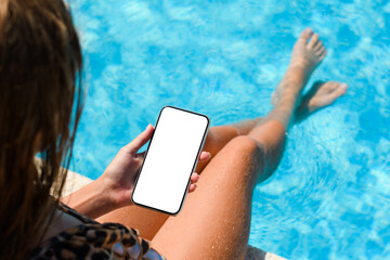 Young girl with phones near the pool. Selective focus. Summer vacation concept