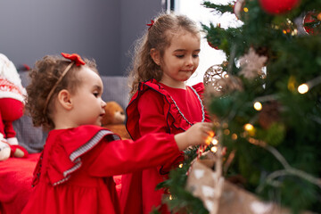 Canvas Print - Adorable girls smiling confident decorating christmas tree at home