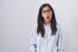 © Krakenimages.com - Young hispanic woman wearing glasses in shock face, looking skeptical and sarcastic, surprised with open mouth