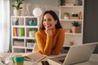 © Zamrznuti tonovi - Cheerful businesswoman at desk with laptop at home office.