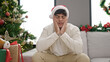 © Krakenimages.com - Young hispanic man celebrating christmas sitting on sofa looking upset at home