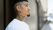 © Krakenimages.com - Cool, tattooed young latin man giving a serious look, outdoors. a relaxed pose on a sunny city street, concentrating on his urban lifestyle.