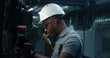 Professional heavy industry worker inspects and sets up piping system. African American engineer injures finger at workplace. Industrial specialist works at modern factory, plant or energy facility.