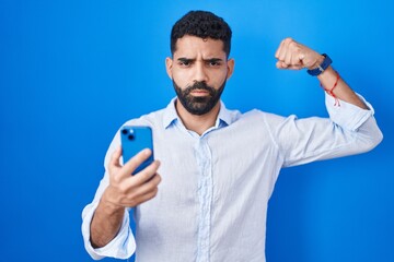 Sticker - Hispanic man with beard using smartphone typing message strong person showing arm muscle, confident and proud of power