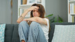 © Krakenimages.com - Young beautiful hispanic woman sitting on sofa with sad expression at home