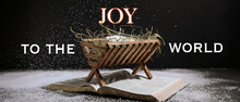 Manger With Dummy Of Baby, Holy Bible And Snow On Dark Background. Concept Of Christmas Story