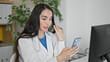 © Krakenimages.com - Young beautiful hispanic woman doctor doing video call with smartphone at the clinic