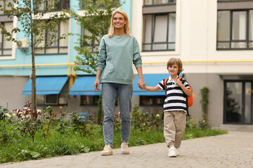 Sticker - Happy woman and her little son on their way to kindergarten outdoors