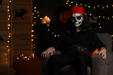 Canvas Print - Man in scary pirate costume with skull makeup against blurred lights indoors, space for text. Halloween celebration