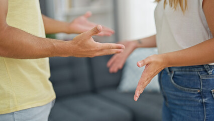 Canvas Print - Man and woman couple standing together arguing at home