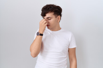 Canvas Print - Young non binary man wearing casual white t shirt tired rubbing nose and eyes feeling fatigue and headache. stress and frustration concept.