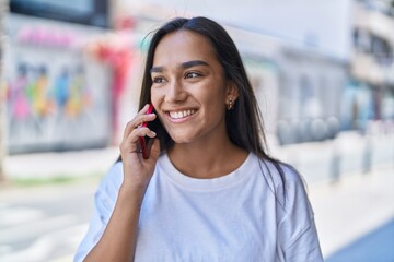 Canvas Print - Young beautiful hispanic woman smiling confident talking on the smartphone at street