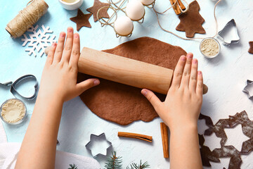 Wall Mural - Woman rolling out gingerbread dough for Christmas cookies on gradient background