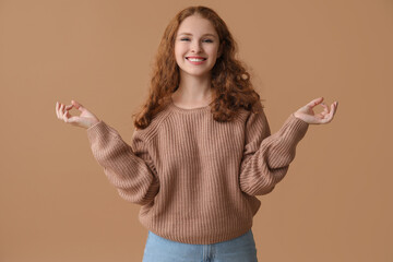 Wall Mural - Portrait of relaxed young woman meditating on brown background