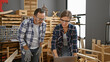 © Krakenimages.com - Two skillful carpenters, man and woman connecting online on laptop amid sawdust and timbers at their carpentry workshop, navigating the woodworking business hand-in-hand like true partners